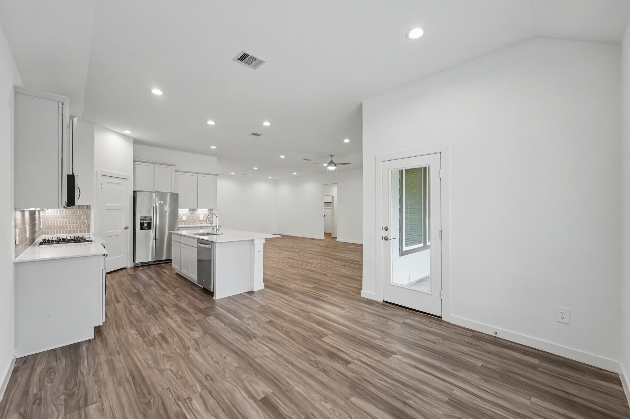 14162 Primrose Ridge Lane Conroe, TX 77384 - Photo 20 of 48 Spacious open-concept kitchen and living area with modern finishes, featuring sleek hardwood floors, stainless steel appliances, and ample natural light.