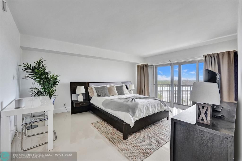 1523 East Hillsboro Boulevard, Unit 1031 Deerfield Beach, FL 33441 - Photo 31 of 78 a bedroom with a large bed and a flat screen television