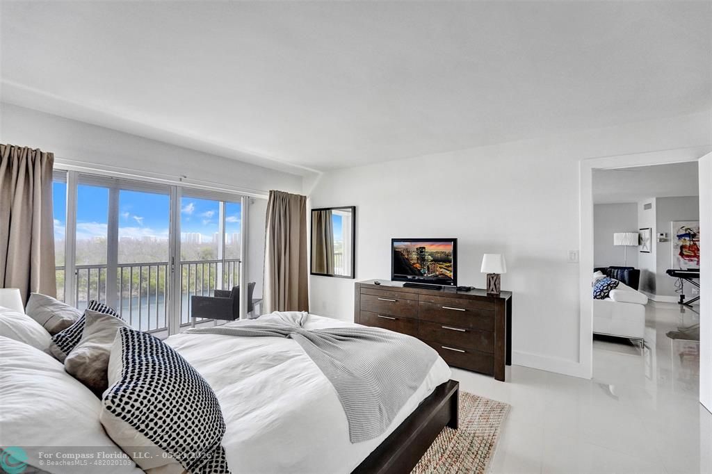 1523 East Hillsboro Boulevard, Unit 1031 Deerfield Beach, FL 33441 - Photo 34 of 78 a bedroom with a bed and a large window