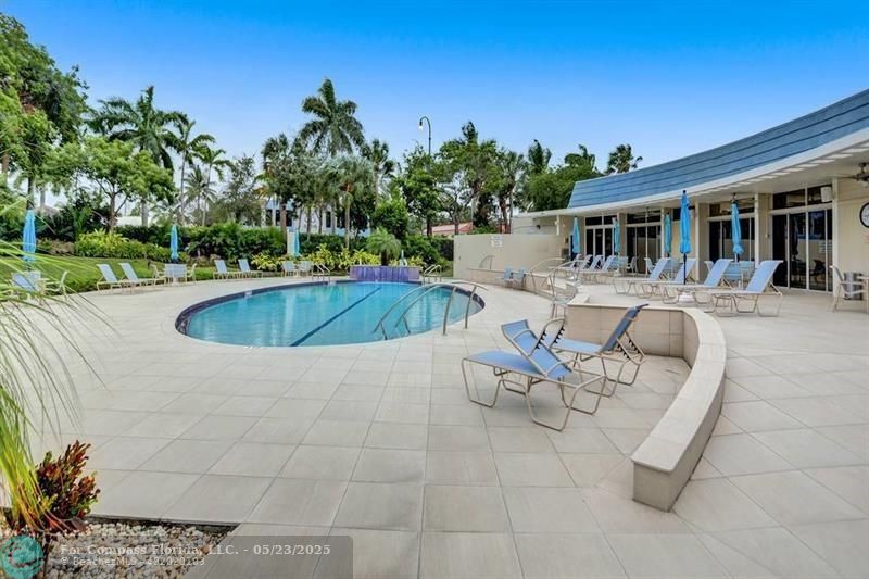 1523 East Hillsboro Boulevard, Unit 1031 Deerfield Beach, FL 33441 - Photo 71 of 78 a view of a swimming pool with outdoor seating and plants