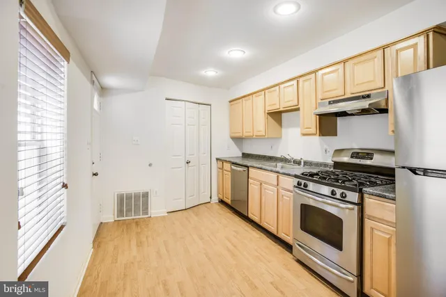 a kitchen with stainless steel appliances a stove a sink and a refrigerator