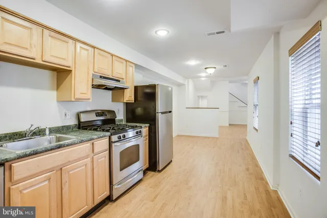 a kitchen with stainless steel appliances granite countertop a refrigerator a stove a sink and a microwave