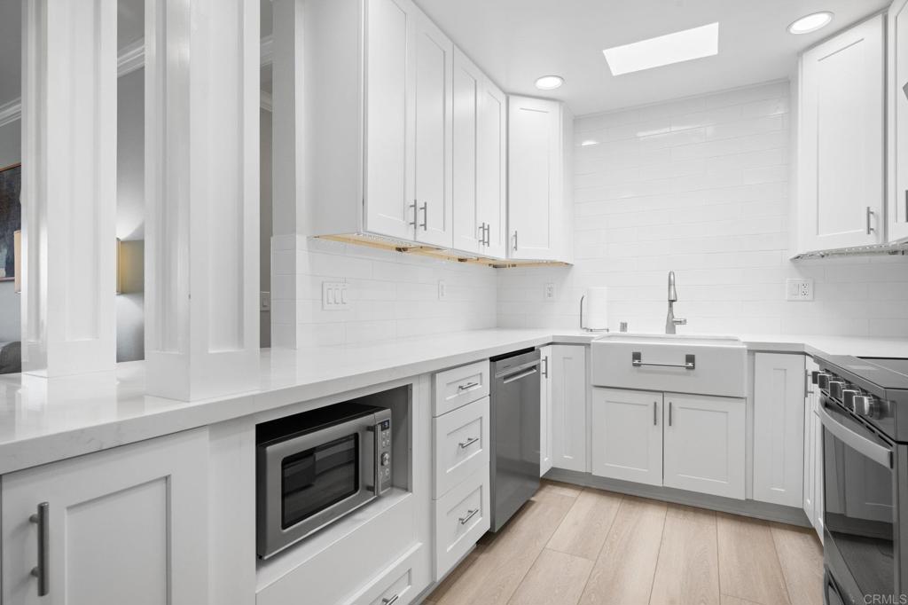 528 E Avenue Coronado, CA 92118 - Photo 6 of 19 a kitchen with white cabinets stainless steel appliances and sink