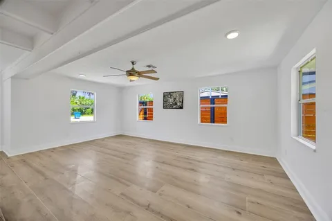 an empty room with windows and wooden floor