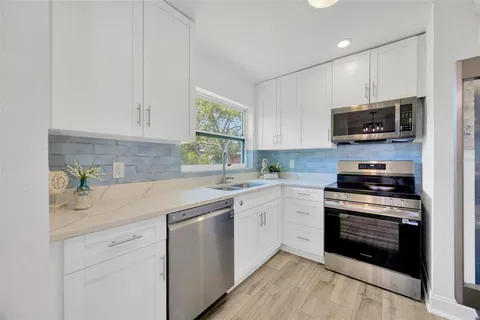 a kitchen with stainless steel appliances granite countertop a stove sink and cabinets