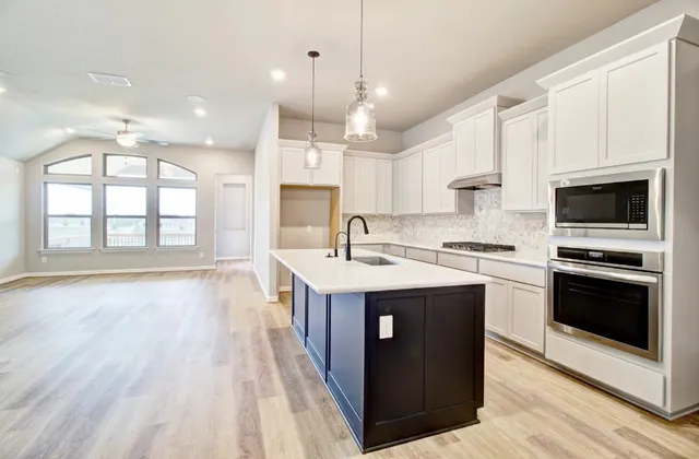 a large kitchen with stainless steel appliances granite countertop a stove and a sink