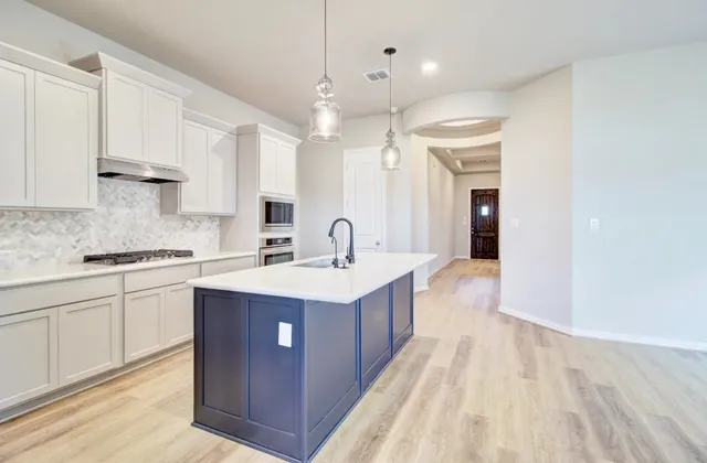a large kitchen with a sink and cabinets