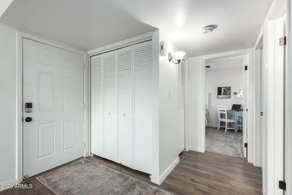 a view of a hallway with wooden floor windows and a living room