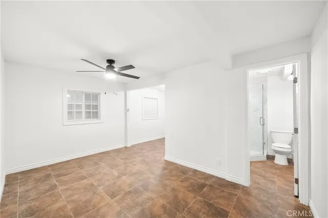a kitchen with granite countertop a refrigerator a sink a stove and white cabinets