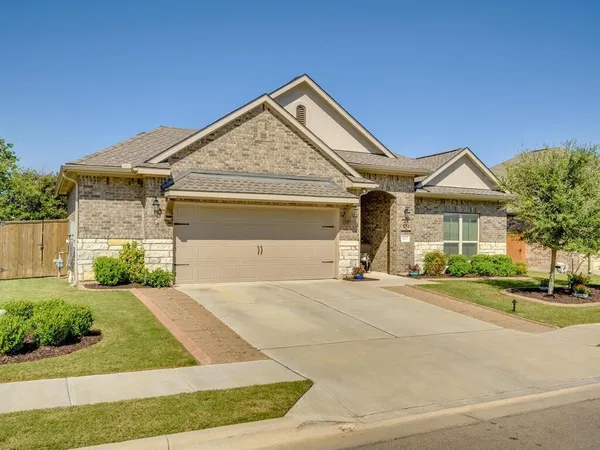 a front view of a house with a garden and garage