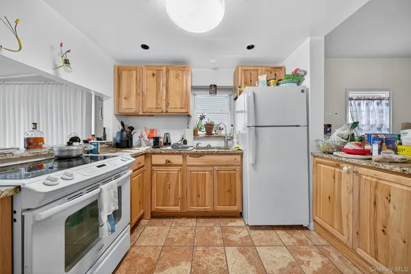 a kitchen with a refrigerator sink and white cabinets