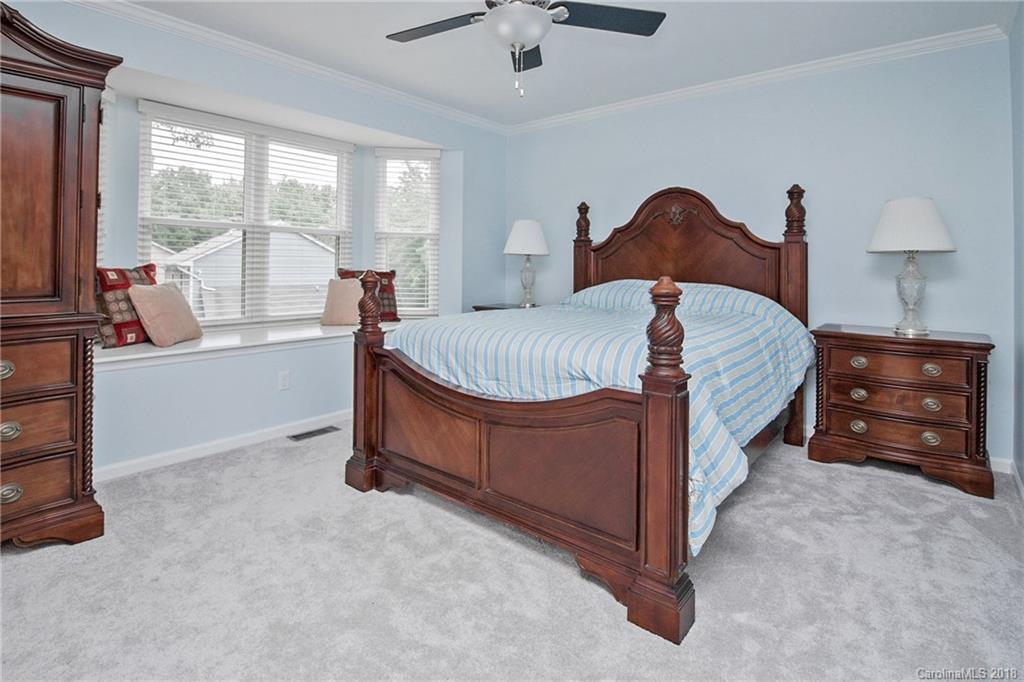 9331 Marshbrooke Road Charlotte, NC 28105 - Photo 11 of 20 a spacious bedroom with a bed and a chandelier