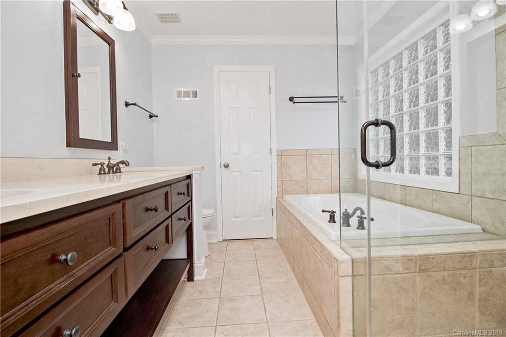 9331 Marshbrooke Road Charlotte, NC 28105 - Photo 12 of 20 a spacious bathroom with a tub sink and mirror