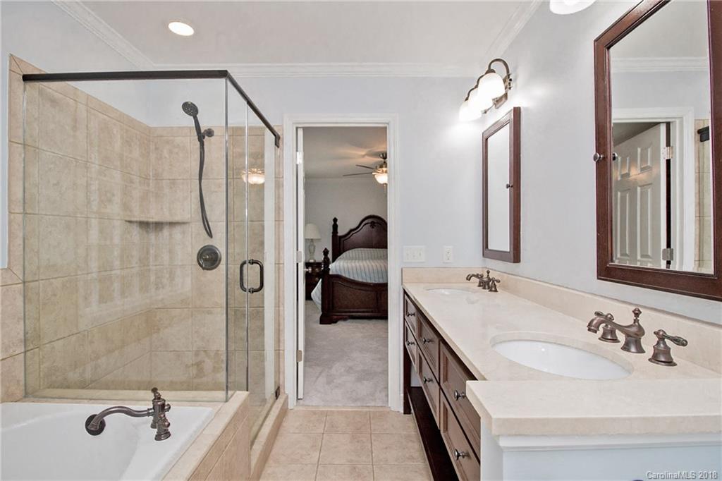 9331 Marshbrooke Road Charlotte, NC 28105 - Photo 13 of 20 a en suite spacious bathroom with a double vanity sink a mirror a shower and a bathtub