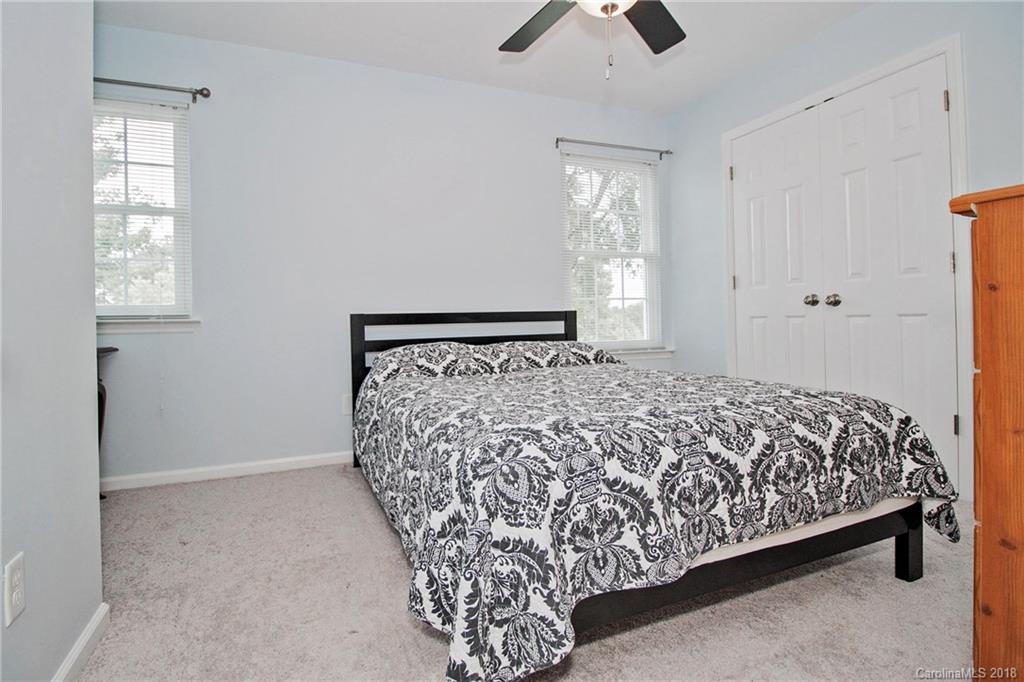 9331 Marshbrooke Road Charlotte, NC 28105 - Photo 14 of 20 a large bed sitting in a bedroom next to a window and a chandelier fan