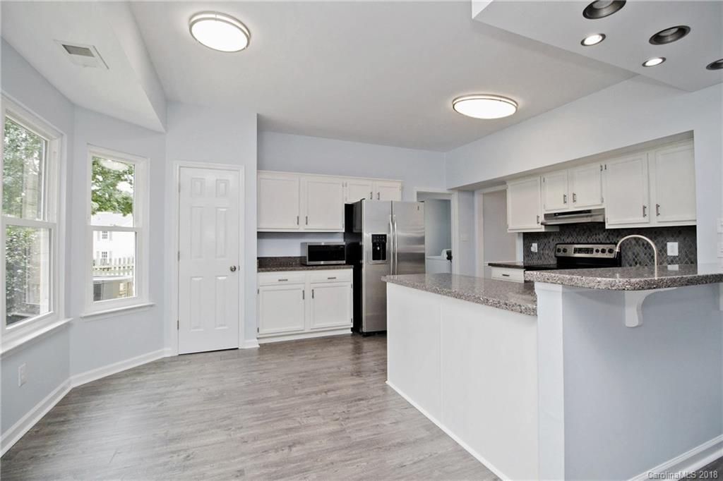 9331 Marshbrooke Road Charlotte, NC 28105 - Photo 7 of 20 a kitchen with white cabinets and appliances