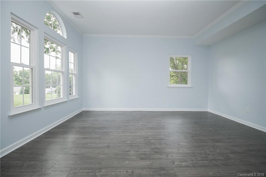 9331 Marshbrooke Road Charlotte, NC 28105 - Photo 10 of 20 an empty room with wooden floor and windows
