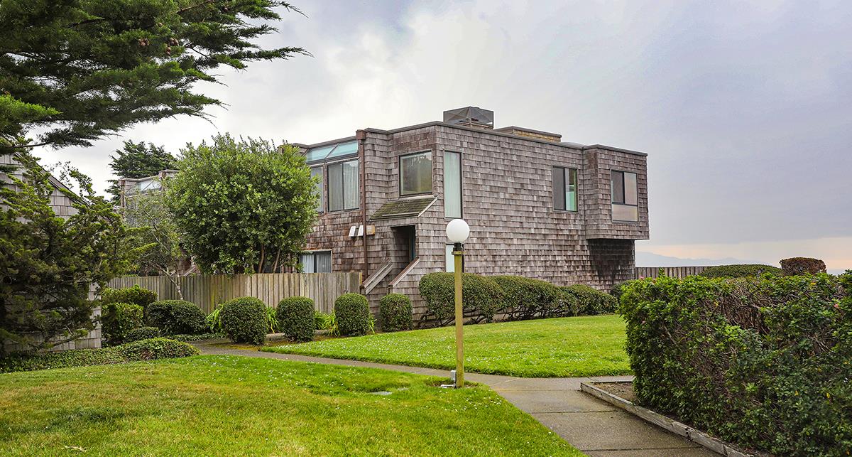 270 Beachview Avenue, Unit 14 Pacifica, CA 94044 - Photo 15 of 41 a large brick building sitting in front of a big yard with plants and large trees