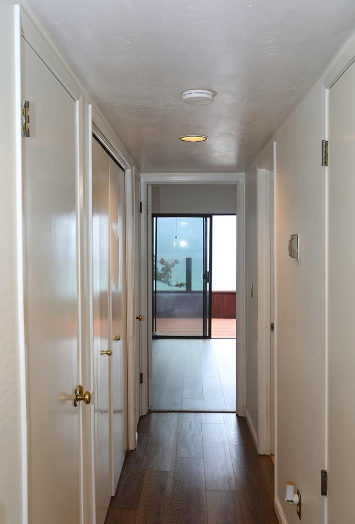 270 Beachview Avenue, Unit 14 Pacifica, CA 94044 - Photo 17 of 41 a view of a hallway with wooden floor and a bathroom