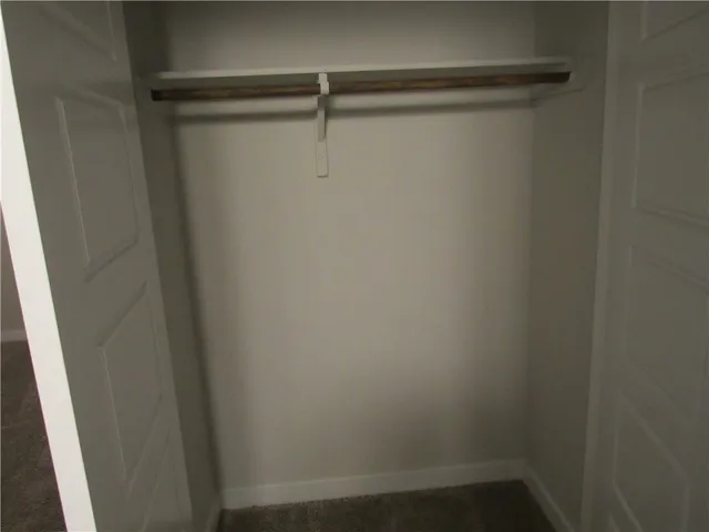 a white toilet sitting next to a white wall