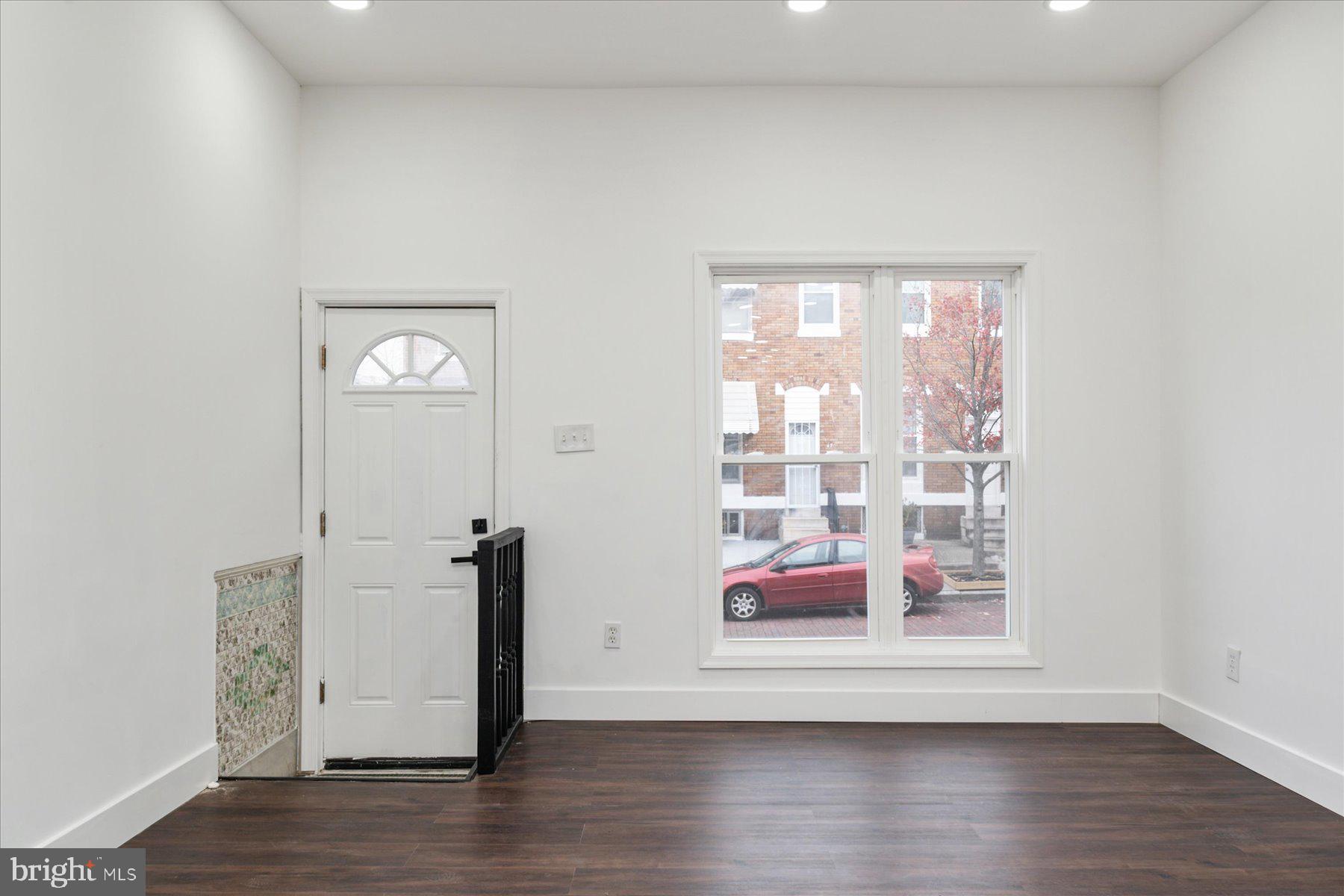 62 Gorman Avenue Baltimore, MD 21223 - Photo 4 of 24 a view of an empty room with wooden floor and a window