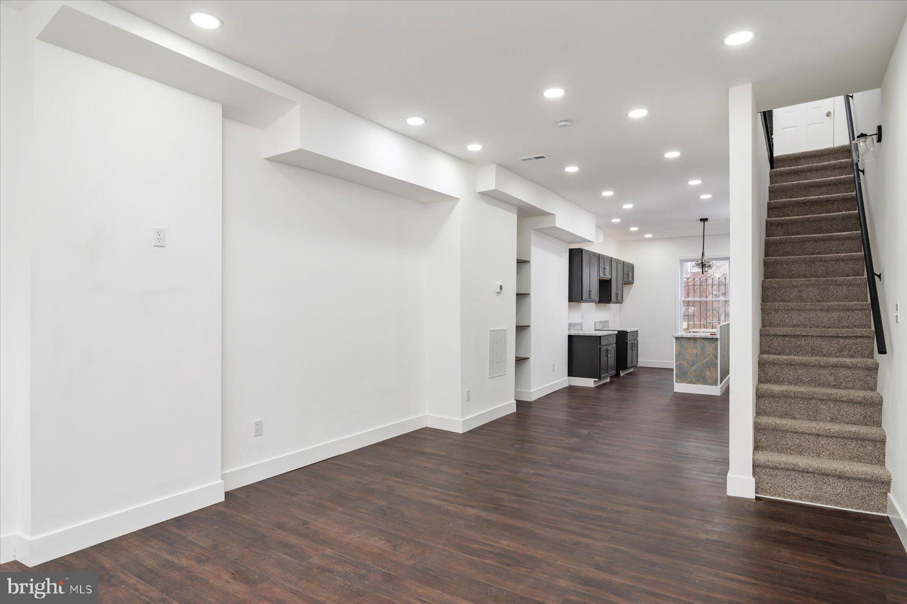 62 Gorman Avenue Baltimore, MD 21223 - Photo 5 of 24 an empty room with wooden floor and windows
