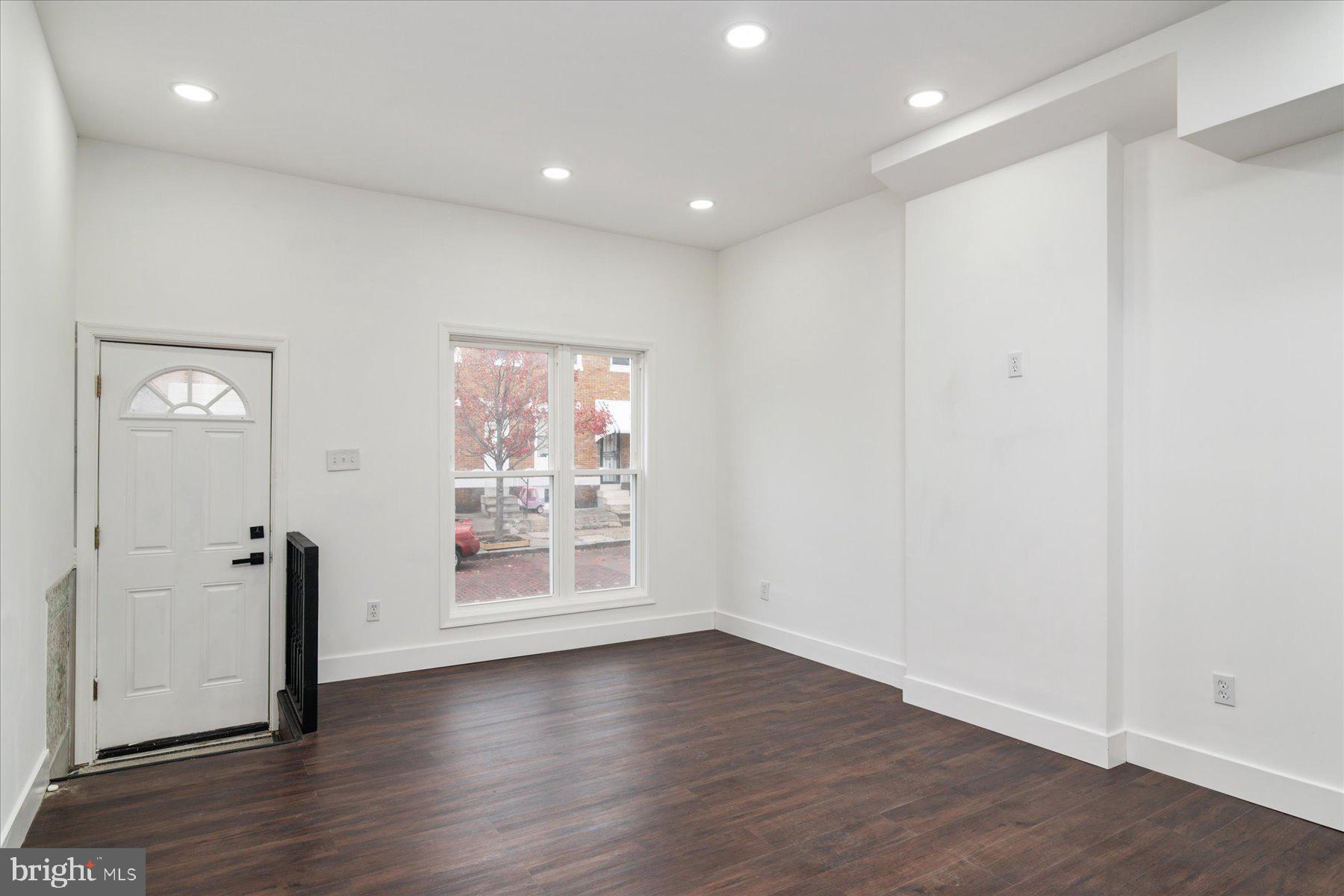 62 Gorman Avenue Baltimore, MD 21223 - Photo 6 of 24 an empty room with wooden floor and windows