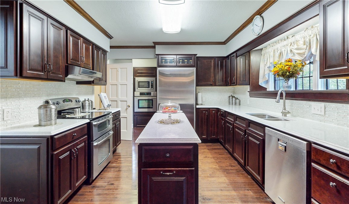 785 Merriman Road Akron, OH 44303 - Photo 11 of 34 Kitchen featuring backsplash, a center island, built in appliances, and hardwood floors