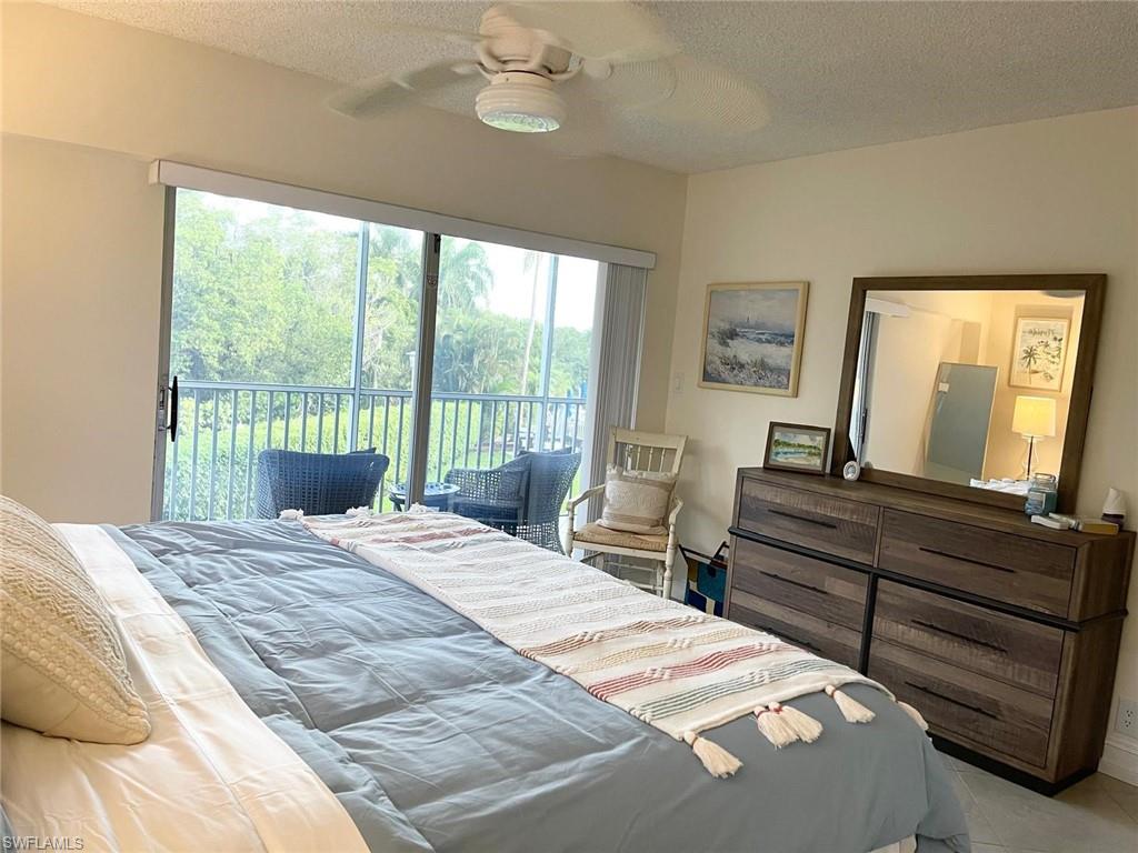 1 Bluebill Avenue, Unit 210 Naples, FL 34108 - Photo 15 of 17 a bedroom with a bed and wooden floor