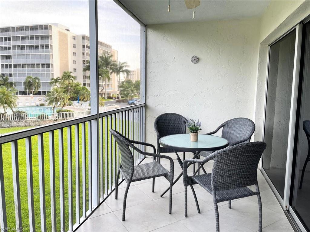 1 Bluebill Avenue, Unit 210 Naples, FL 34108 - Photo 16 of 17 a view of a balcony furniture and dining room