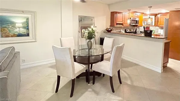 a kitchen with stainless steel appliances kitchen island granite countertop a table and chairs