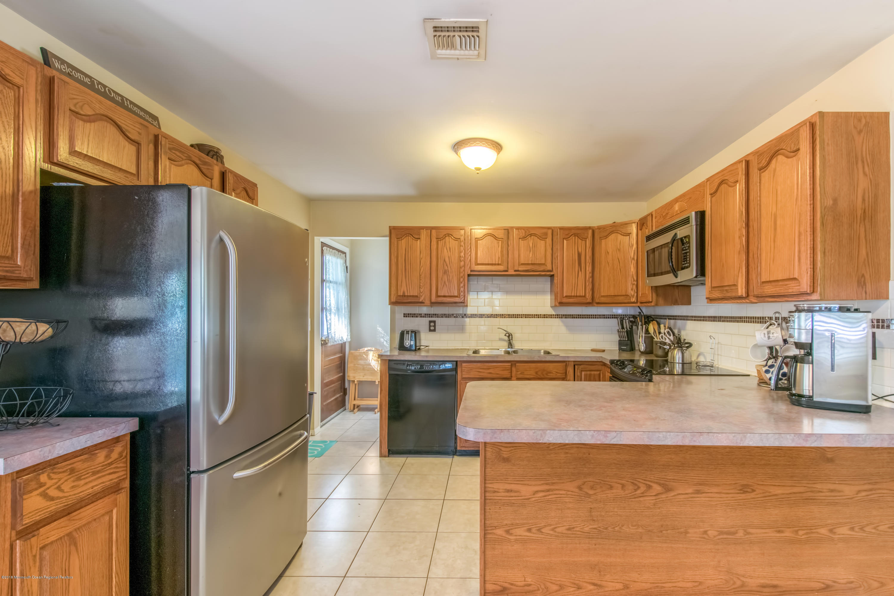 156 Captain Road Manahawkin, NJ 08050 - Photo 11 of 39 a kitchen with stainless steel appliances granite countertop a refrigerator a stove and a sink with wooden floor
