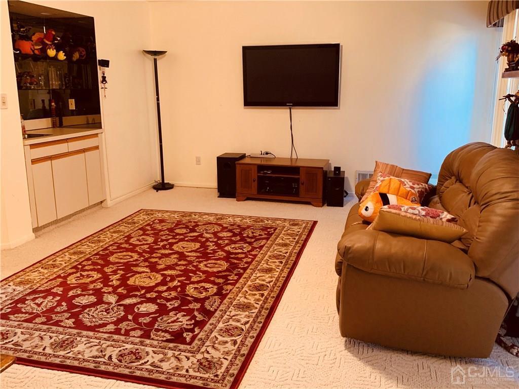 4702 Stonehedge Road Edison, NJ 08820 - Photo 21 of 24 a living room with a couch and a flat screen tv