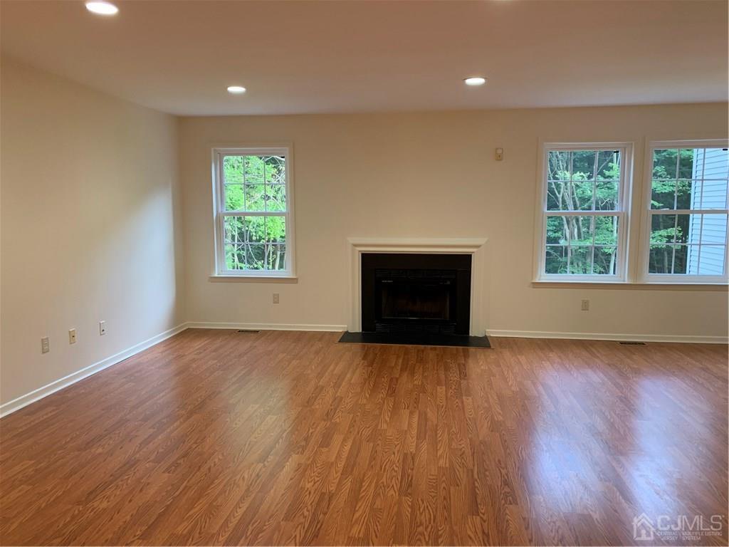 4702 Stonehedge Road Edison, NJ 08820 - Photo 7 of 24 an empty room with wooden floor and windows