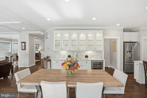 a kitchen with stainless steel appliances kitchen island granite countertop a sink and stove a refrigerator with wooden floors