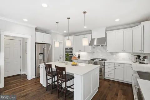 a kitchen with stainless steel appliances granite countertop a stove a refrigerator and a wooden cabinets