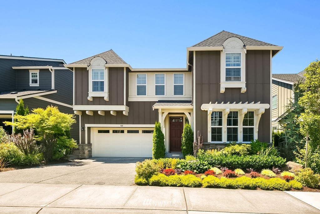 a front view of a house with a yard and potted plants