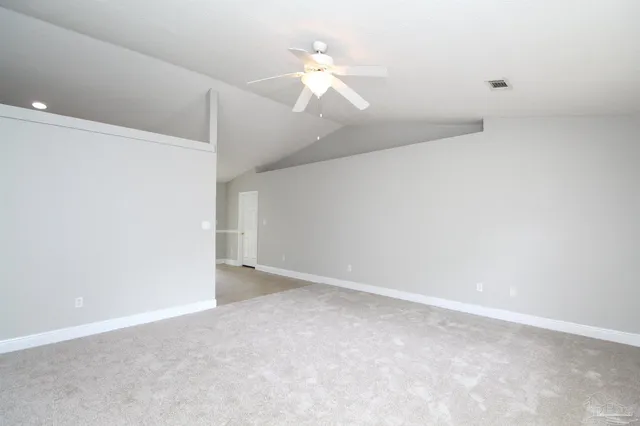 a view of an empty room with a ceiling fan and a window