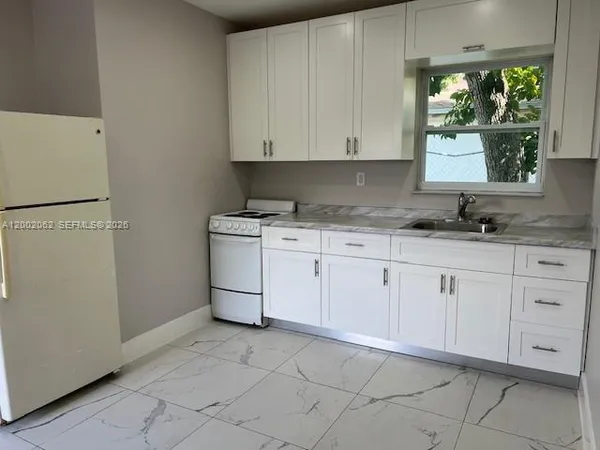 a kitchen with white cabinets and white appliances