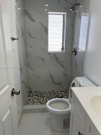 a bathroom with a sink a toilet and shower