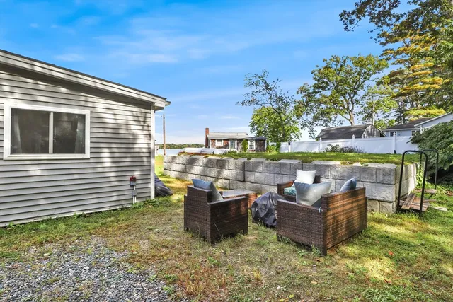a view of a patio with couches chairs potted plants and water view