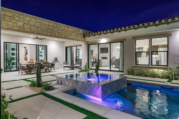 a view of a house with pool lawn chairs and a yard