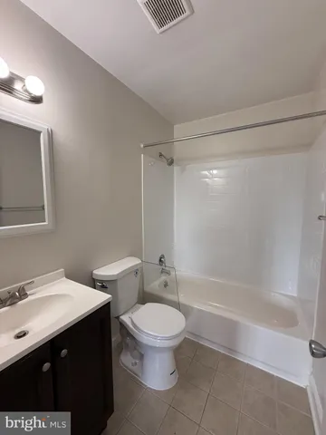 a bathroom with a bathtub shower sink mirror and toilet
