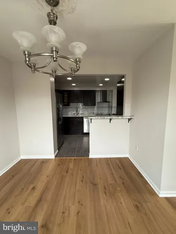 a view of a room with a wooden floor and a ceiling fan