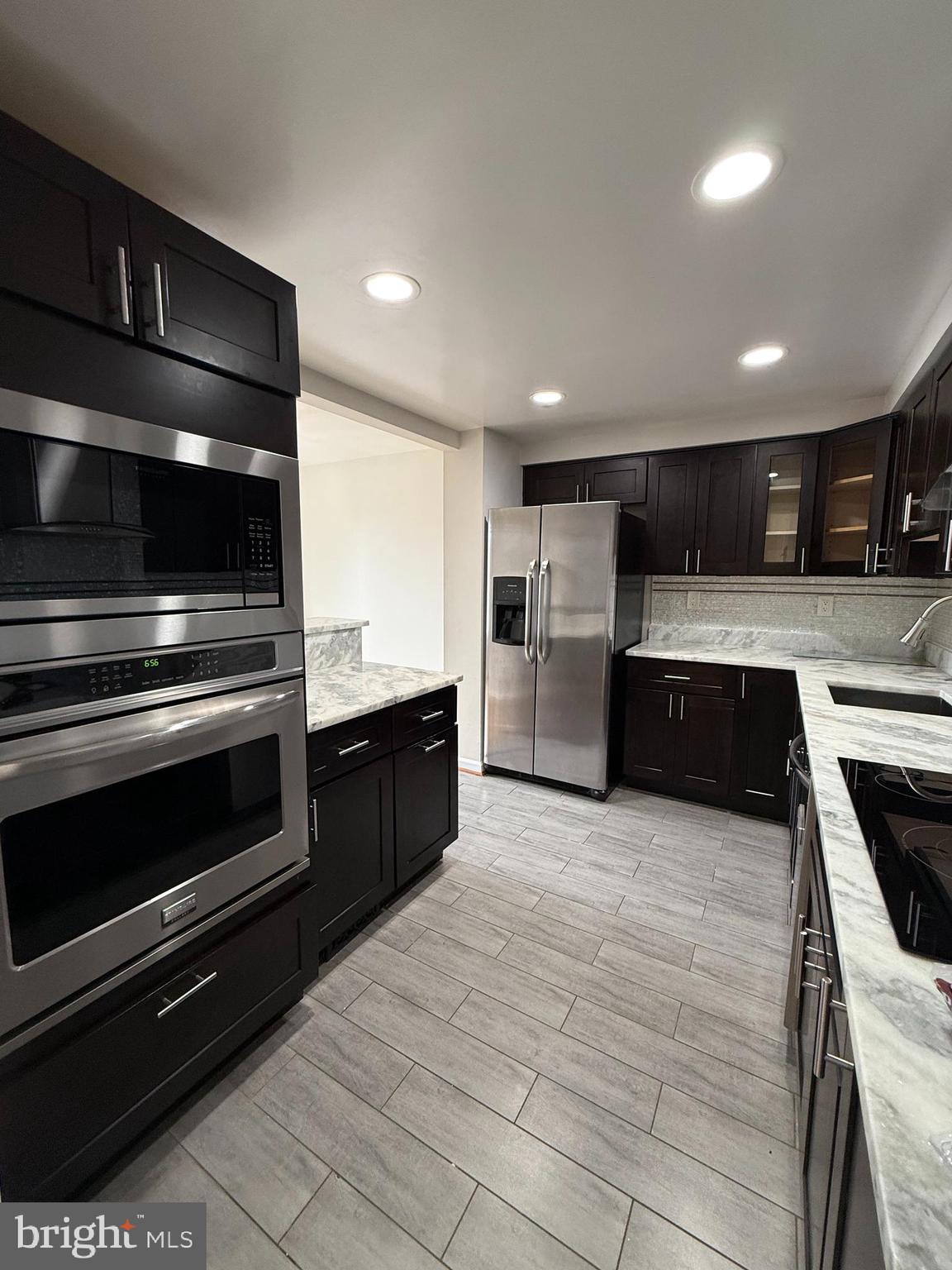 3801 Tremayne Terrace Silver Spring, MD 20906 - Photo 6 of 25 a large kitchen with stainless steel appliances kitchen island granite countertop a stove and a sink