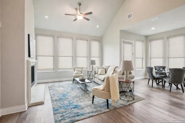 a dining room with furniture a wooden floor and kitchen view