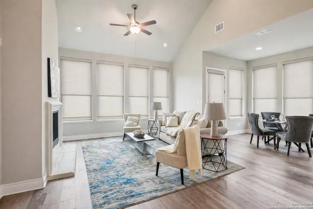 a dining room with furniture a wooden floor and kitchen view