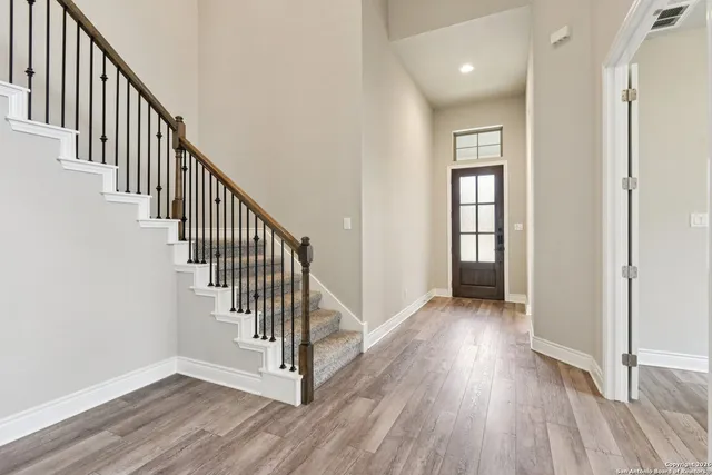 a view of a hallway with wooden floor and entryway