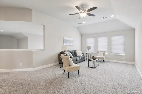 a view of an empty room and chandelier fan