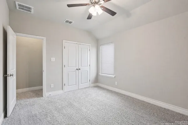 an empty room with a window and a fan